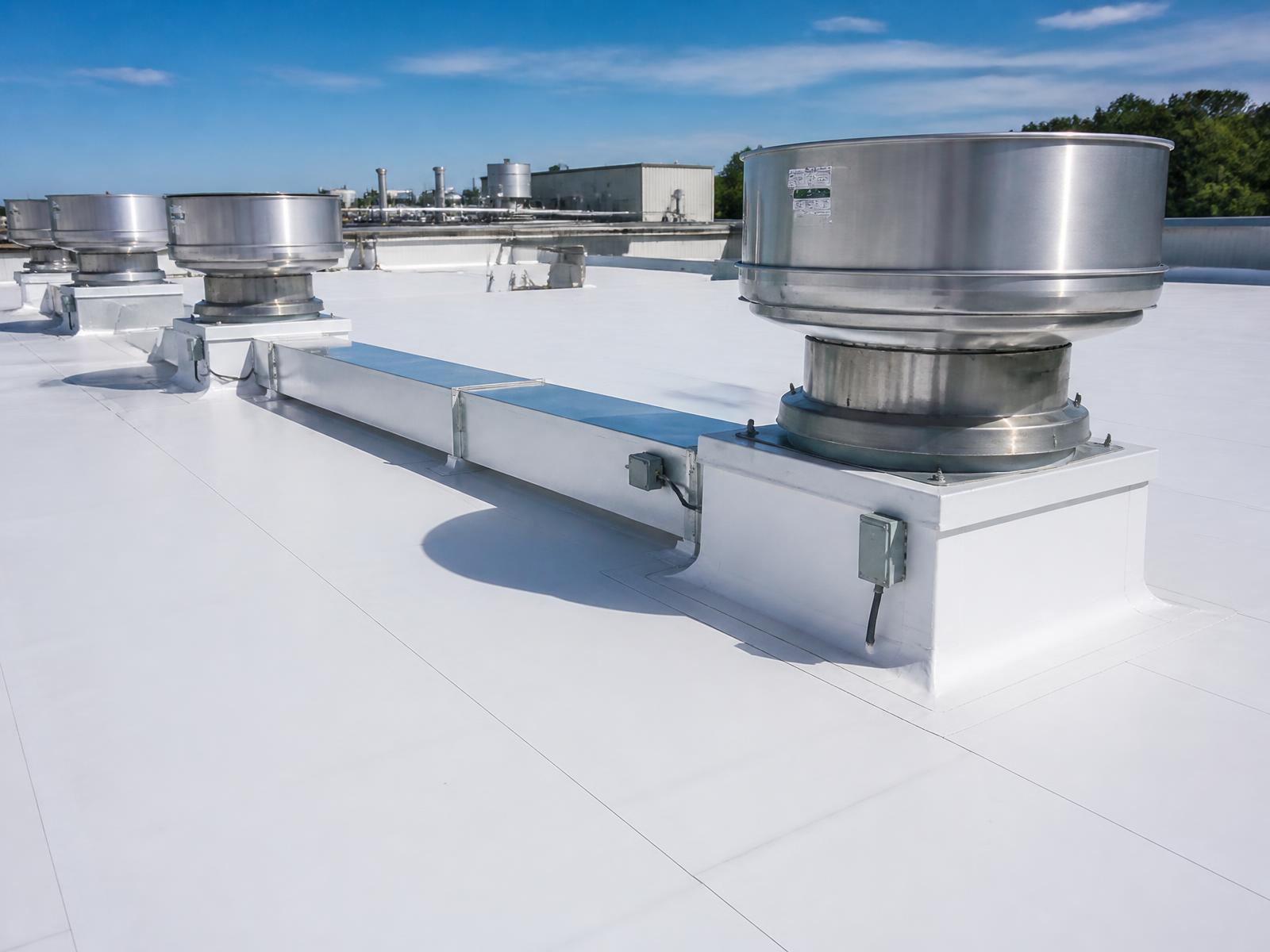 White PVC membrane roof with flashed exhaust curbs on a food processing plant